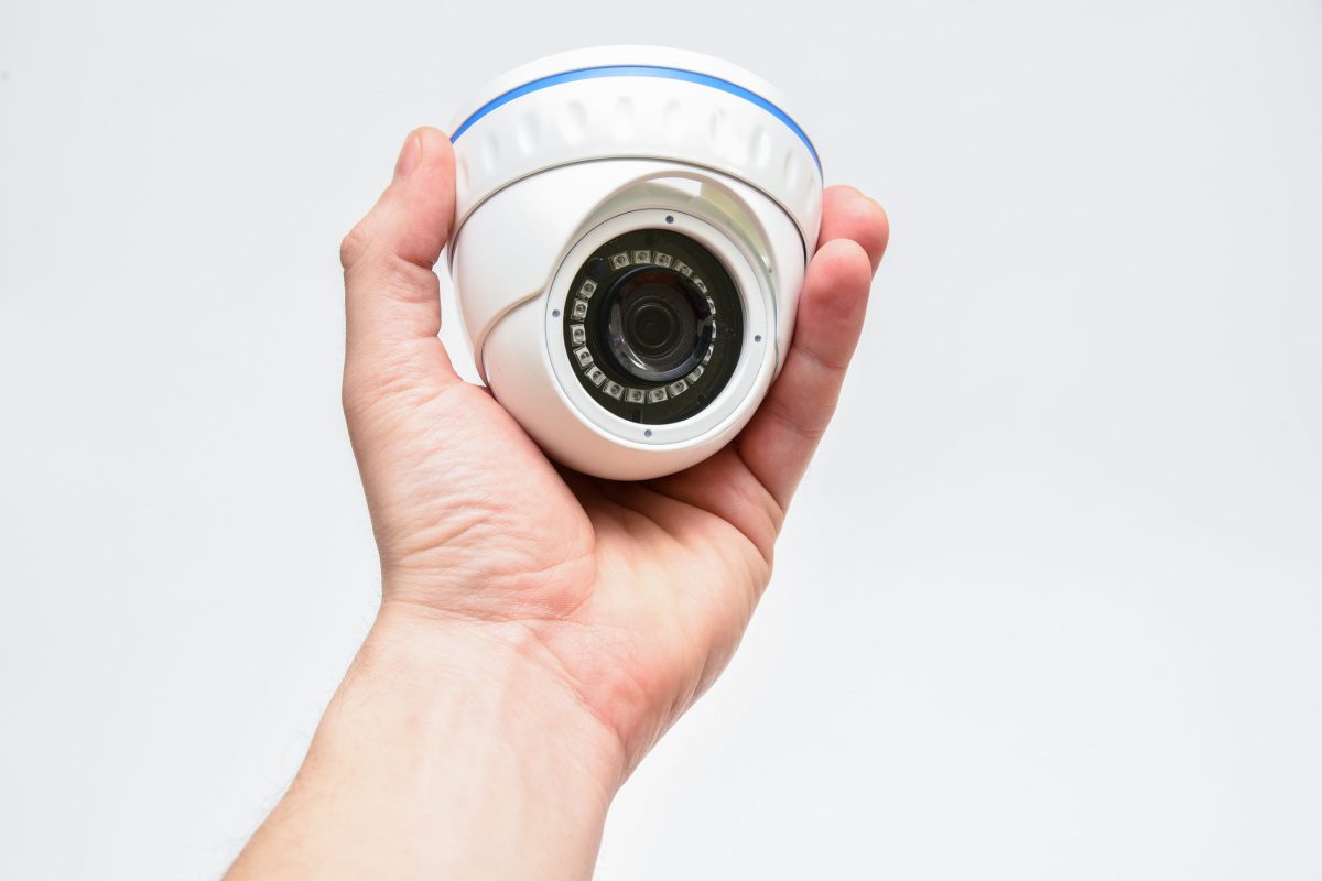 Dome round surveillance camera in male hand